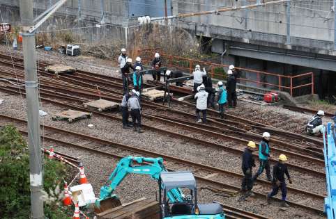 事故現場で設備の復旧に当たる作業員ら＝２０日午後４時半ごろ、薩摩川内市の川内駅付近