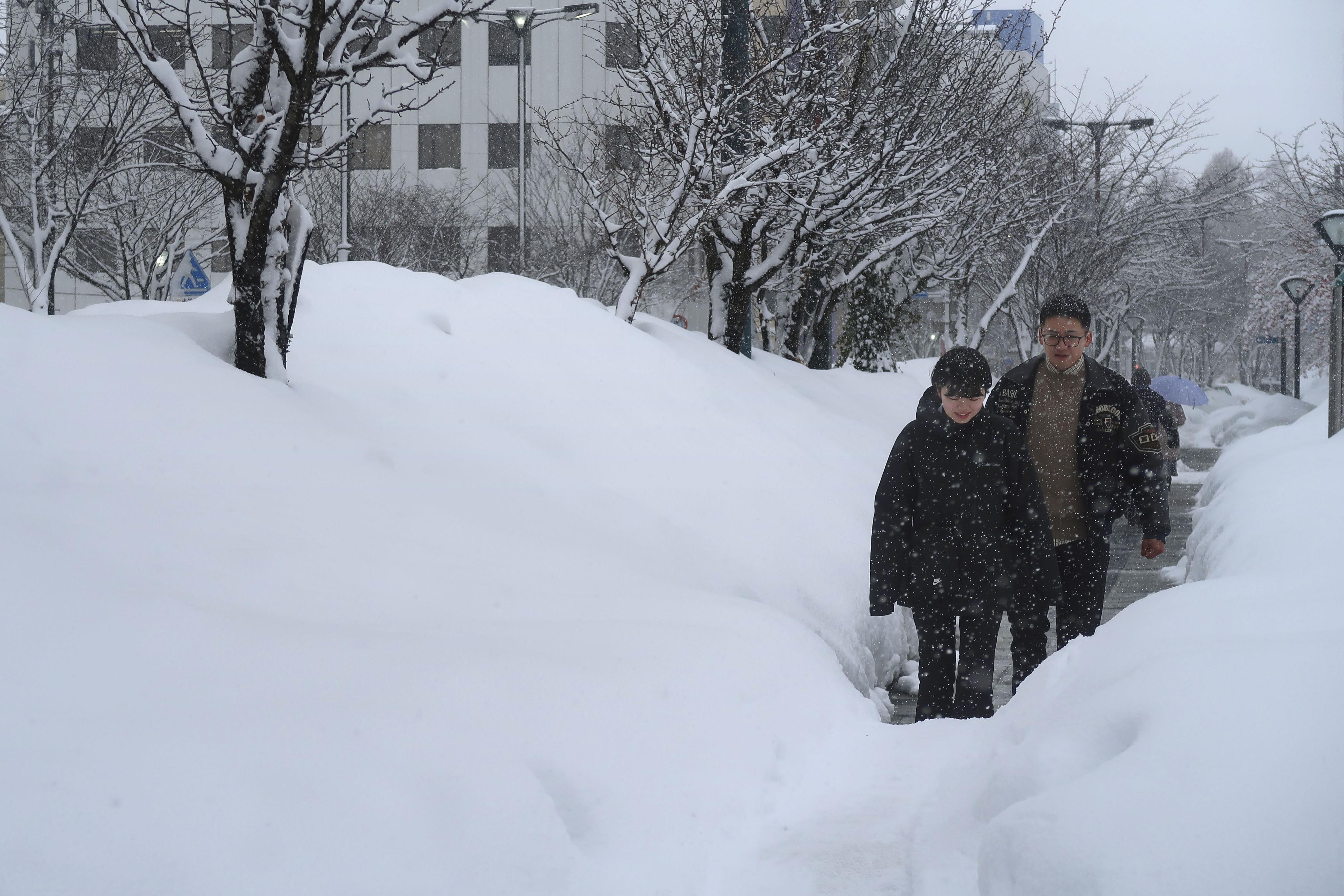 雪が積もった青森市中心部を歩く人＝8日午後