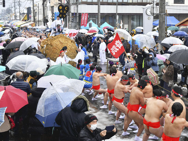 雨の中で力いっぱい俵を引く男衆ら＝会津坂下町