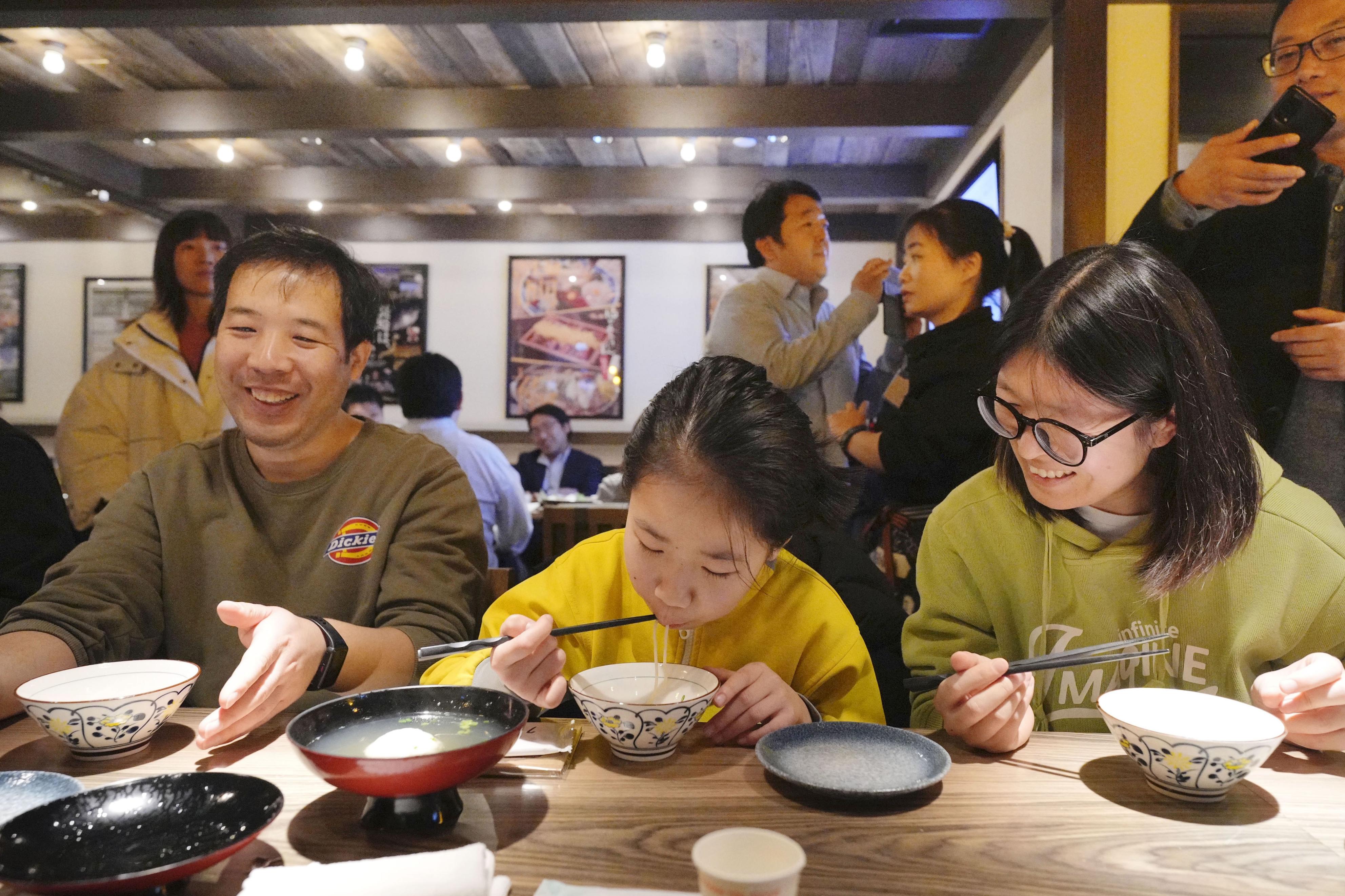 北京市内の日本料理店で開かれた長崎県をPRするイベントで、五島うどんを味わう中国人客＝6日（共同）