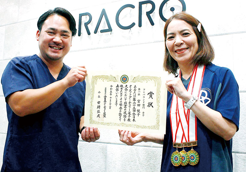 宮田悦子さん（右）と、トレーナーとして支える理学療法士の矢島佑さん＝川越市大中居のラクロ本社