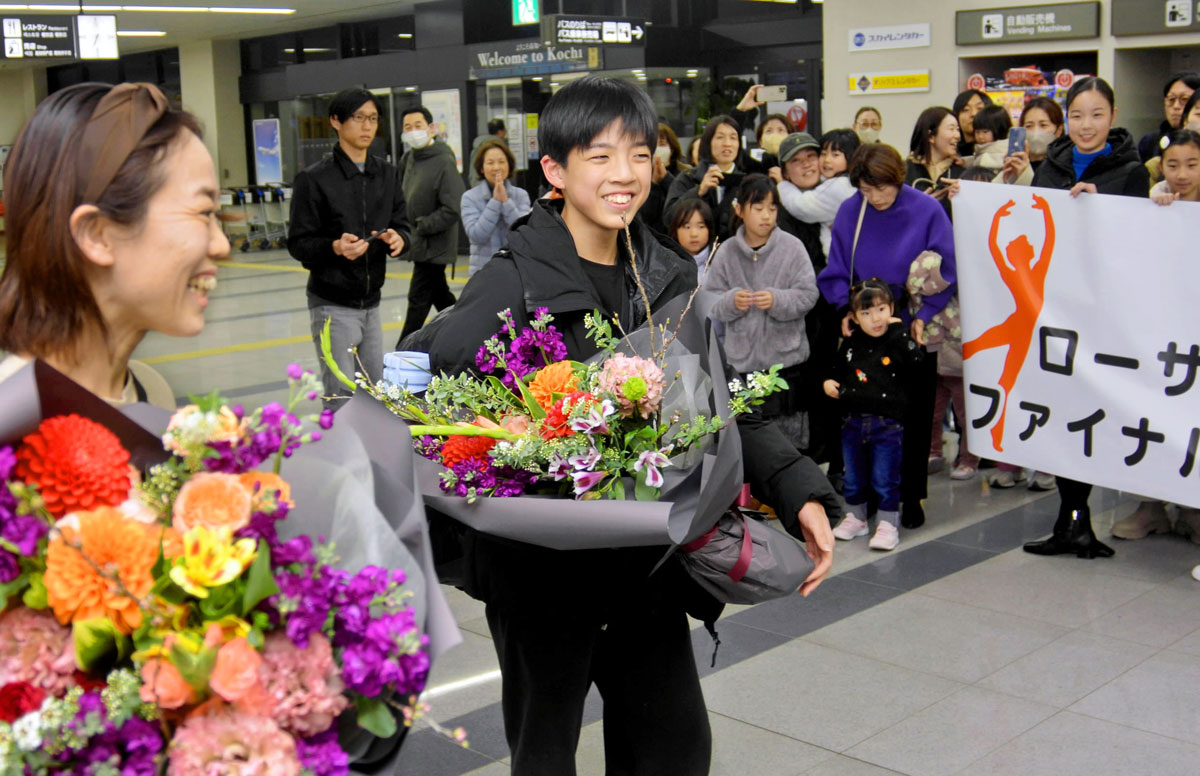 仲間の出迎えを受け、笑顔の福間悠陽さん＝中央＝と指導者の上岡真佐子さん＝左（高知龍馬空港）