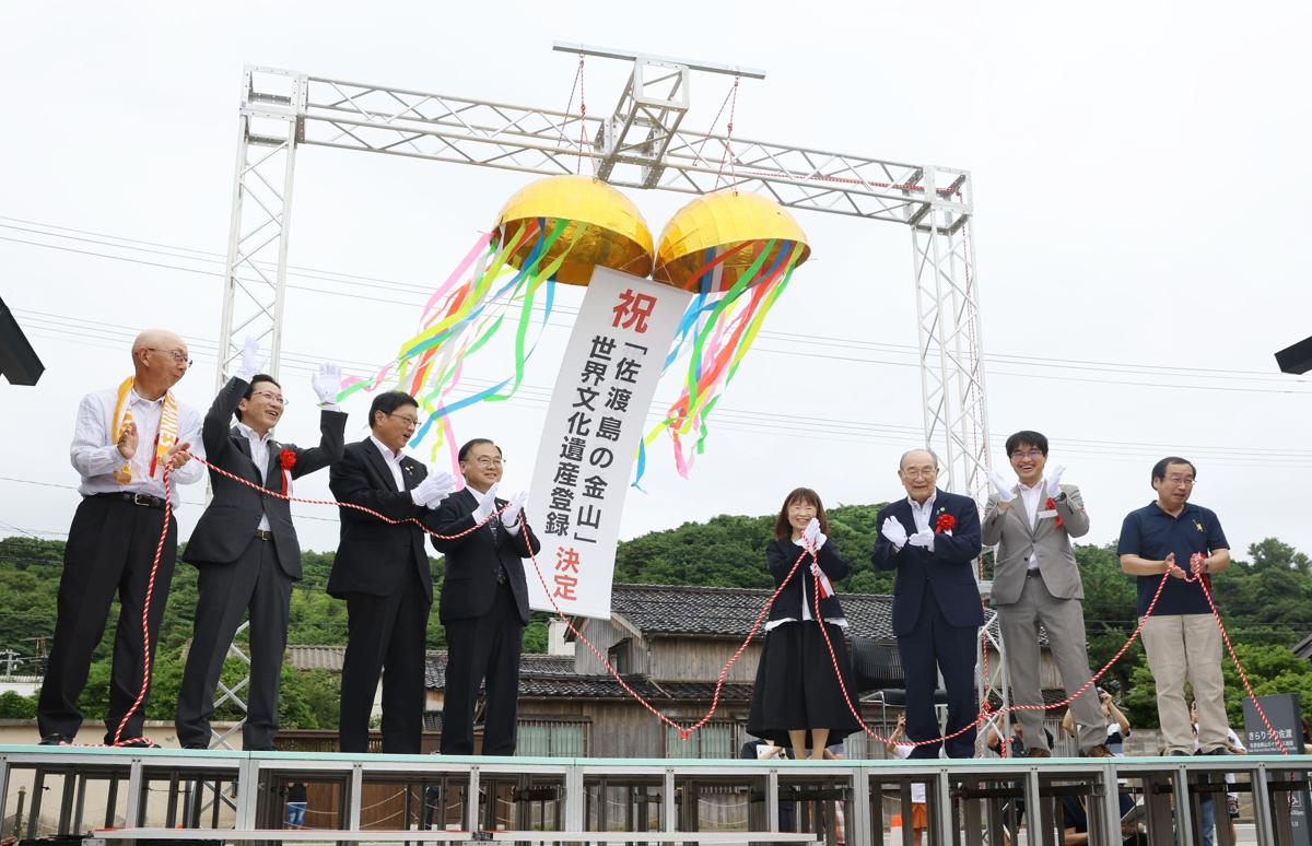 くす玉を割るなどして、世界遺産登録を喜ぶ関係者たち＝７月２７日、佐渡市相川三町目浜町