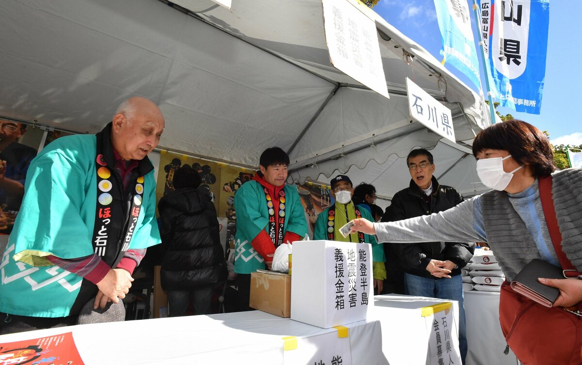 前回大会の石川県人会のブースで、寄付をする来場者に頭を下げる杉本さん＝左端（２０２４年１月21日）