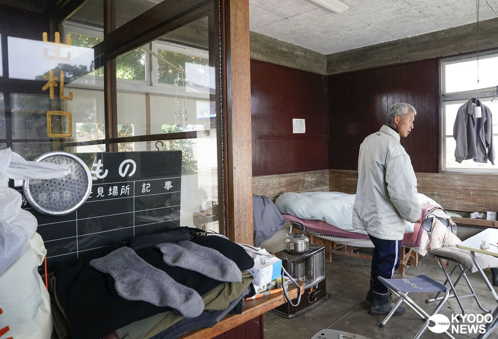 廃線となった「のと鉄道」能登線の正院駅舎で避難生活を送る石川県珠洲市の鎌田一宏さん（６５）。自宅は全壊し、「どこを見ても思い出ばかり。悲しいよ」と涙ぐむ。近所の神社から井戸水をくんできて、生活用水に充てる不自由な生活もまもなく３カ月。どんなに不便でも「命が助かったと思えばたいていのことは耐えられる」とストーブで煮炊きする生活を続けている＝２０２４年３月２９日(共同)　