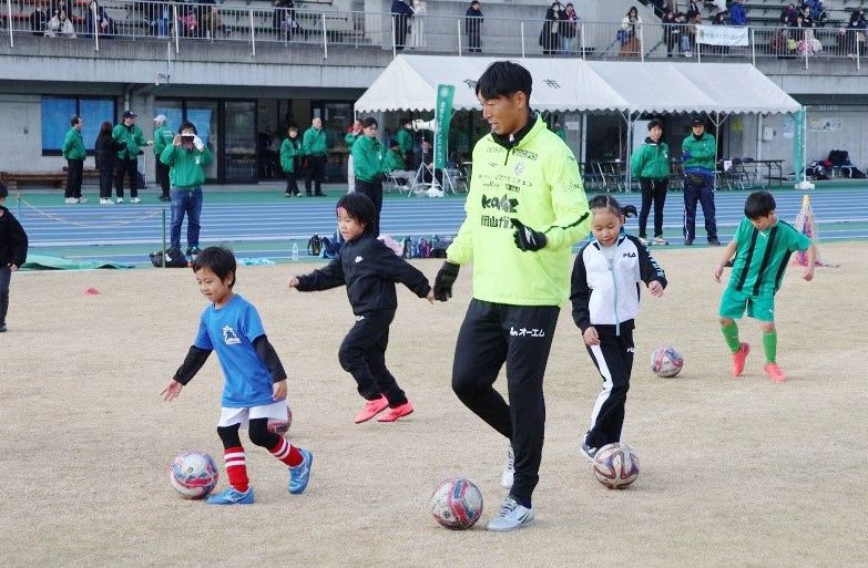 金山選手（中央）とドリブル練習に取り組む児童