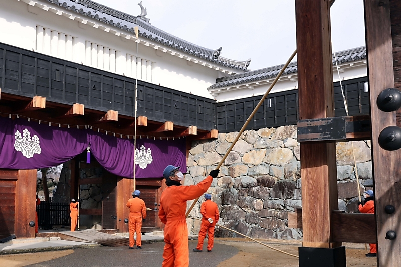 長いほうきで１年間のほこりやクモの巣を払った松本城のすす払い