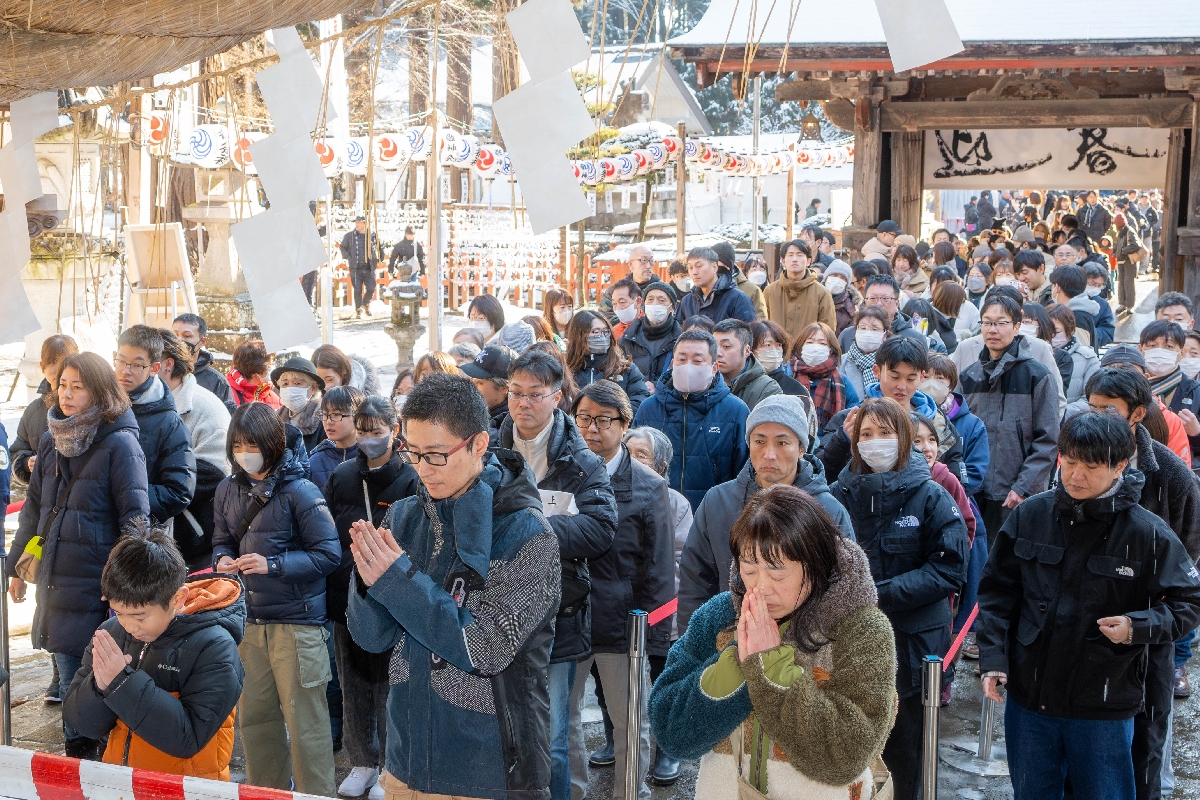 拝殿に向かって手を合わせ、願いを込める参拝者＝午後０時３５分ごろ、八戸市の櫛引八幡宮