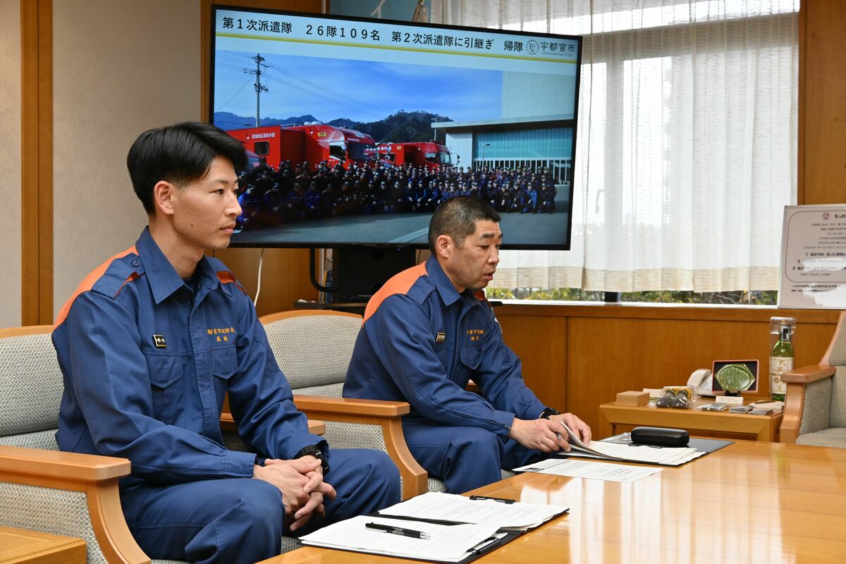 夜間の消火活動などを報告する高橋消防副士長（左）ら