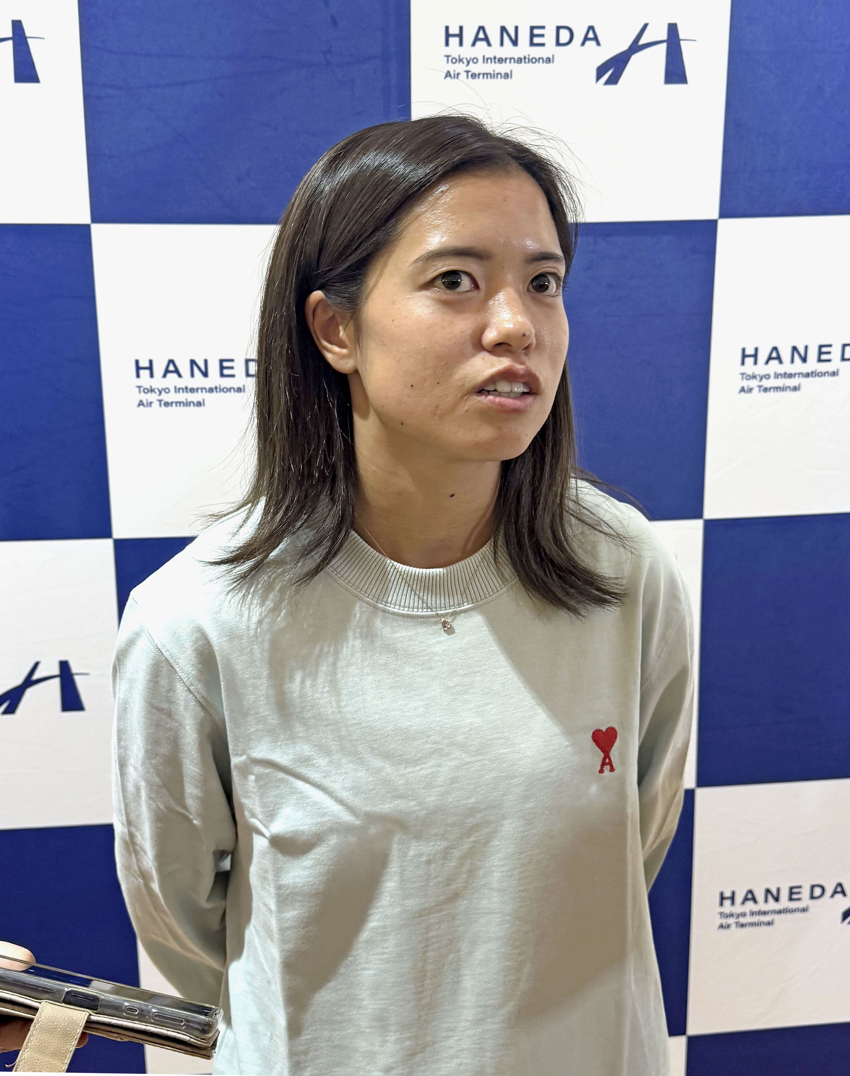 羽田空港で取材に応じるサッカー女子日本代表の長谷川唯＝20日