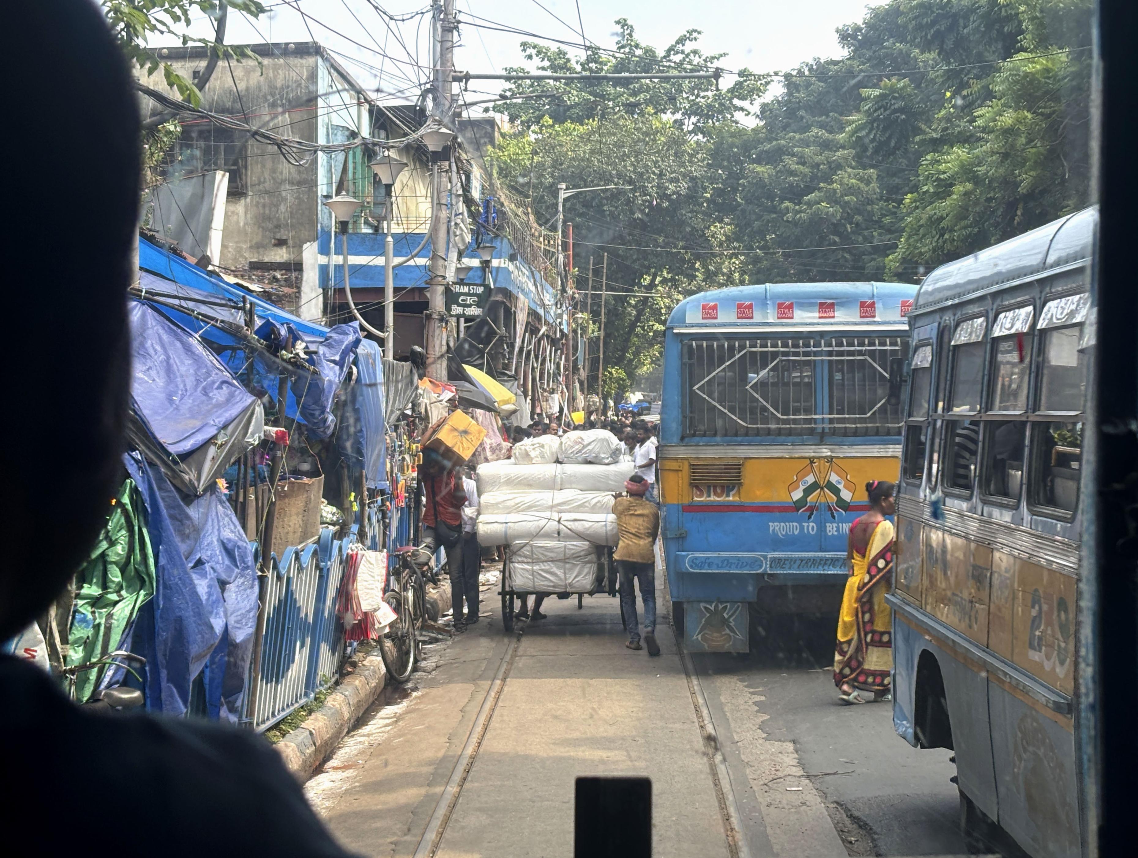 トラムの運転席から前方を見ると、バスや荷車で線路がふさがっている＝2024年10月、インド・コルカタ（共同）