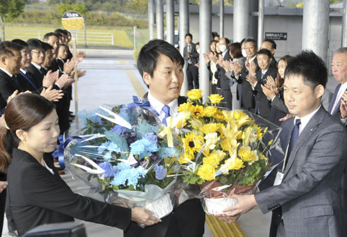 【職員から花束を受け取る稲森市長（中央）＝伊賀市役所で】