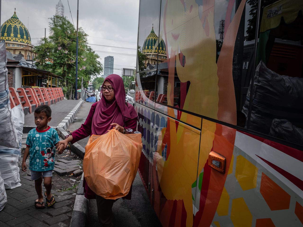 A woman brings used plastic bottles to exchange for bus tickets in Surabaya, East Java.