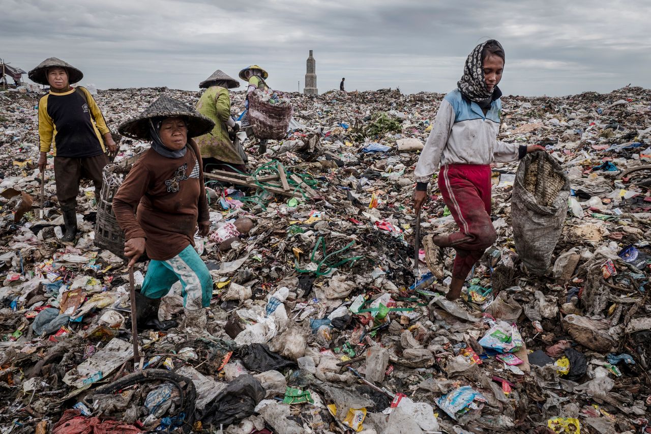 Waste pickers sift through a mountain of garbage at a landfill site near Sidoarjo.