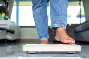 a close up of a person's feet on a white scale at home wonder why they're not losing weight