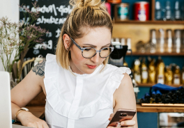 Femme à son bureau tenant son téléphone