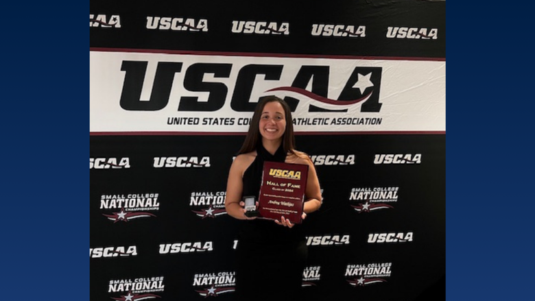 A college student holding an award