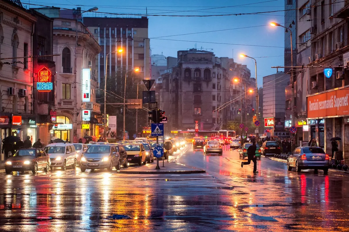 A wet road in a city at dusk