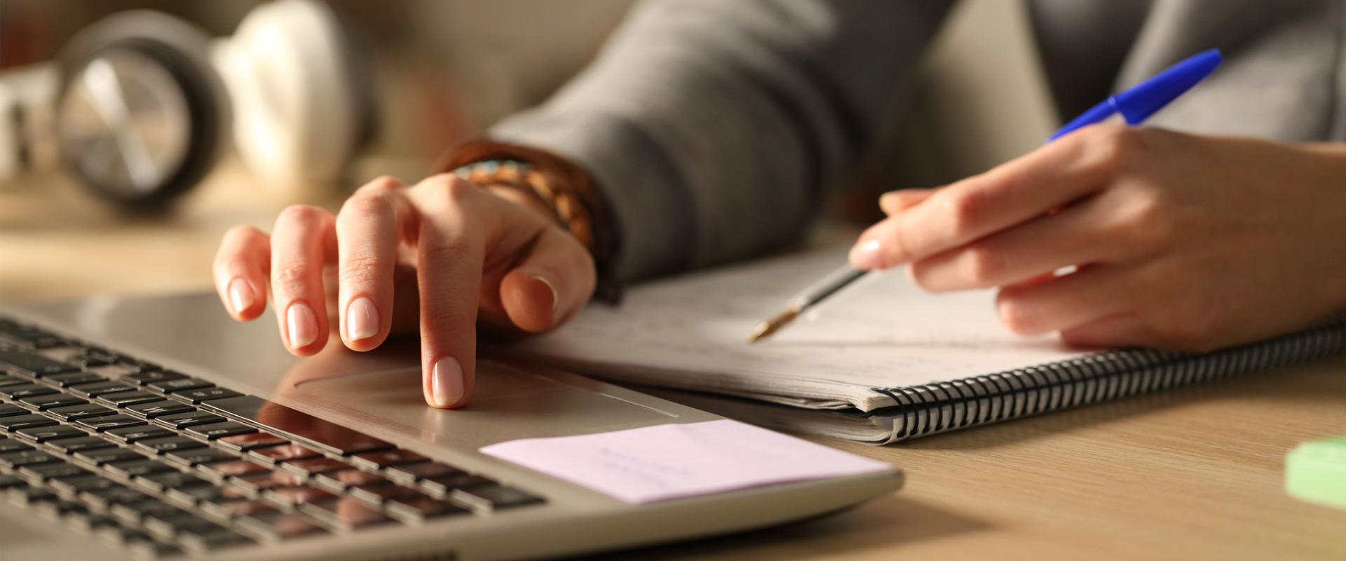 person using laptop and paper tablet