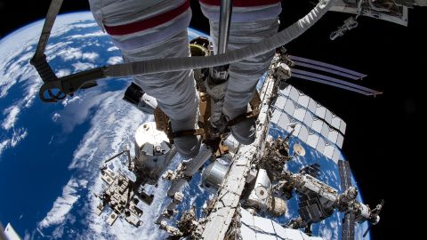 This view from NASA spacewalker Thomas Marshburn&apos;s camera points toward his U.S. spacesuit legs, downward from the Canadarm2 robotic arm that he is attached to, and toward the International Space Station below him on December 2, 2021. The station&apos;s prominent features include (from left) the Kibo laboratory module&apos;s external pallet, the truss structure, its radiators, and the orbiting lab&apos;s Russian segment.