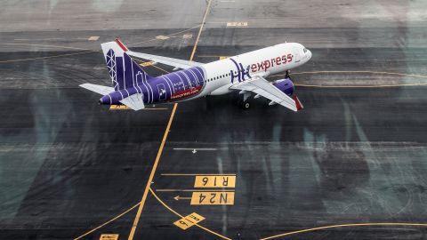 An aircraft operated by Hong Kong Express Airways Ltd. travels under the Skybridge at Hong Kong International Airport in Hong Kong, China, on Tuesday, Nov. 1, 2022. Hong Kong International Airport opened a bridge connecting a terminal and satellite concourse on Tuesday, part of a wider HK$9 billion ($1.15 billion) upgrade even as a full recovery in air traffic remains far off. Photographer: Lam Yik/Bloomberg via Getty Images