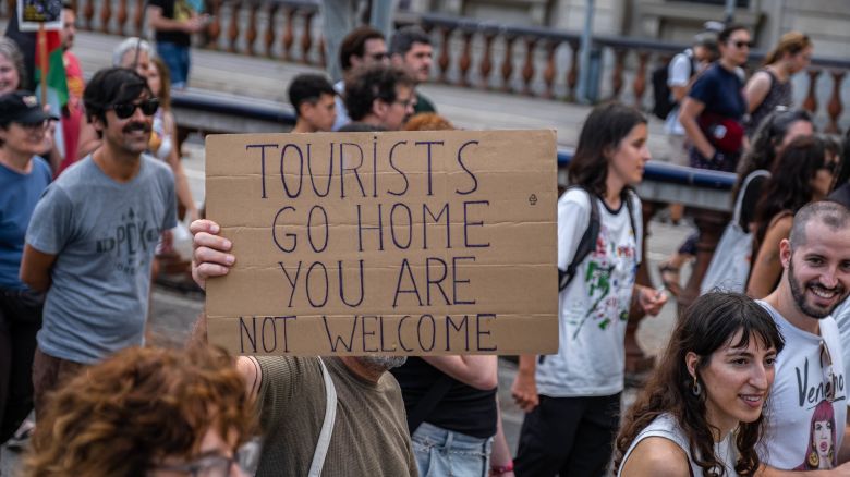 BARCELONA, CATALONIA, SPAIN - 2024/07/06: An anti-tourism placard is seen during the demonstration. More than 3,000 people demonstrated against the tourist overcrowding suffered by the city of Barcelona and in favor of tourism reduction policies. The demonstration involved symbolically closing hotel establishments, bars and restaurants while heading towards Barceloneta, one of the neighborhoods that suffers the most from the presence of tourism. (Photo by Paco Freire/SOPA Images/LightRocket via Getty Images)