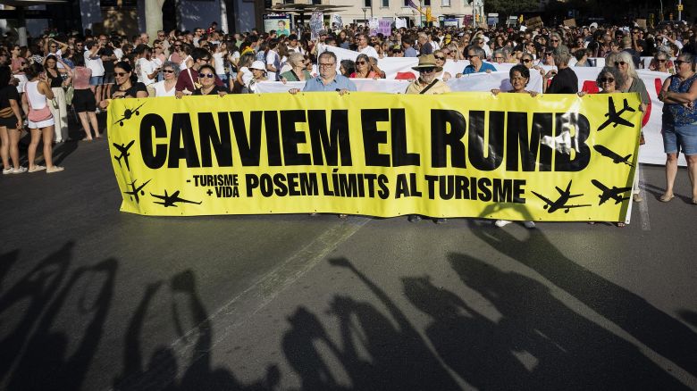 Protesters hold a banner which reads as "Let&apos;s change course" as they take part in a demonstration against overtourism and housing prices on the island of Mallorca in Palma de Mallorca on July 21, 2024. (Photo by JAIME REINA / AFP) (Photo by JAIME REINA/AFP via Getty Images)