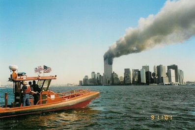 A Coast Guard RHIB off Manhattan on the morning of 11 September 2001 (not a USCG photograph).Photo by Chan Irwin, the owner of Irwin Marine in Red Bank, New Jersey.  He had taken a fast boat out into the harbor on 9/11/2001 but got turned back before the radio call request for aid was sent out.  He gave a copy of his photograph to his friend Mike Harmon who forwarded this digital copy to the Historian's Office.  

(Info. provided by Matthew Riva, WSJ Night Photo Editor, 2021).
