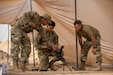 U.S. Army Spc. Samuel Vazquez, left, and Spc. Moises Valdez, center, with 90th Aviation Support Battalion (ASB), 11th Combat Aviation Brigade, inspect an M249 light machine gun at Camp Buehring, Kuwait, July 10, 2022. U.S. Soldiers deployed in support of Operation Spartan Shield and Operation Inherent Resolve participated in an Expert Soldier Badge test hosted by 90th ASB, mobilized as Task Force Rattlers, to assess their mastery of physical fitness, marksmanship and other critical skills necessary for combat readiness. (U.S. Army photo by Spc. Zachary Danaher)