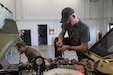 U.S. Army Reserve Staff Sgt. Patrick McCoy, assigned to the 282nd Engineer Company, 416th Engineer Command based in Fort Carson, Colo., and a military technician based at the Equipment Concentration Site-42, prepares to use a digital multimeter to check continuity of a Joint Light Tactical Vehicle connector while Staff Sgt. Allan Zink, assigned to the Expeditionary Combat Aviation Brigade based in Fort Carson, and a military technician based at the Equipment Concentration Site-42, Fort Carson, looks on a laptop to tell him what pin will be tested in the Joint Light Tactical Vehicle Phase One course at the 88th Readiness Division Fort McCoy, Wis., Draw Yard March 1, 2022.  (U.S. Army Reserve photo by Sgt. 1st Class Clinton Wood).