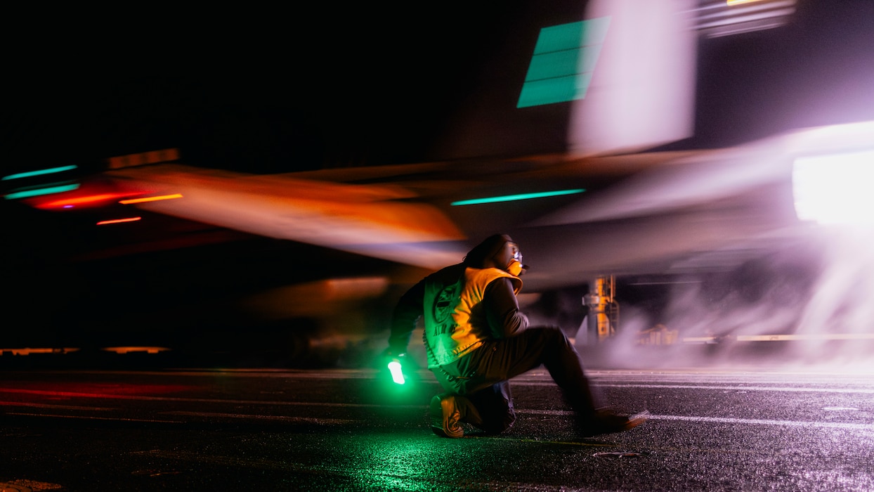 ABE2 Diangelo Watson signals to launch an aircraft from USS George Washington (CVN 73) in the Pacific Ocean.