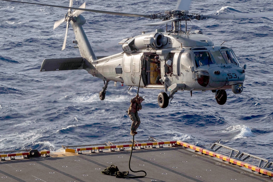 A Marine fast-ropes from an MH-60S Sea Hawk helicopter assigned to HSC-23 during an air power demonstration rehearsal aboard USS Boxer (LHD 4) in the Pacific Ocean.