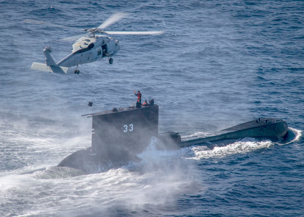 A U.S. Navy MH-60R Sea Hawk helicopter from HSM-41 hovers over the Peruvian navy submarine BAP Pisagua (SS 33) during an exercise off the coast of San Diego.