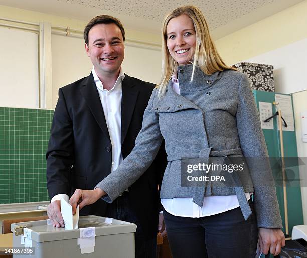Oliver Luksic, top candidate of the free democratic FDP party, and his wife Katharina cast their votes at a polling station in Holz, southwestern...