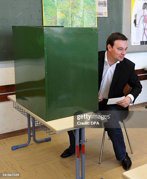 Oliver Luksic, top candidate of the free democratic FDP party, casts his vote at a polling station in Holz, southwestern Germany, during regional...