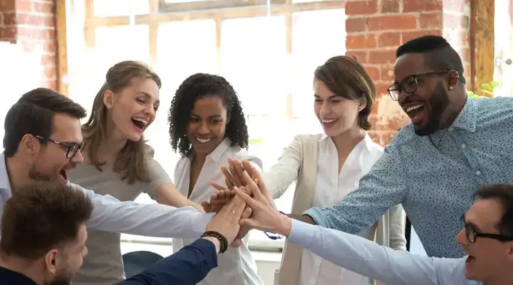 Hands placed on top of each other in a business meeting