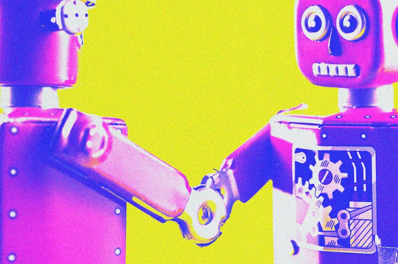 Pink and blue toy robots shaking hands in front of a yellow background