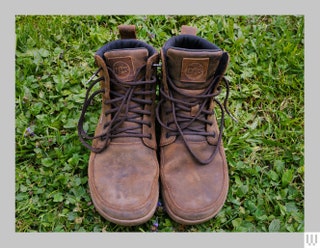 Brown boots with laces sitting in grass