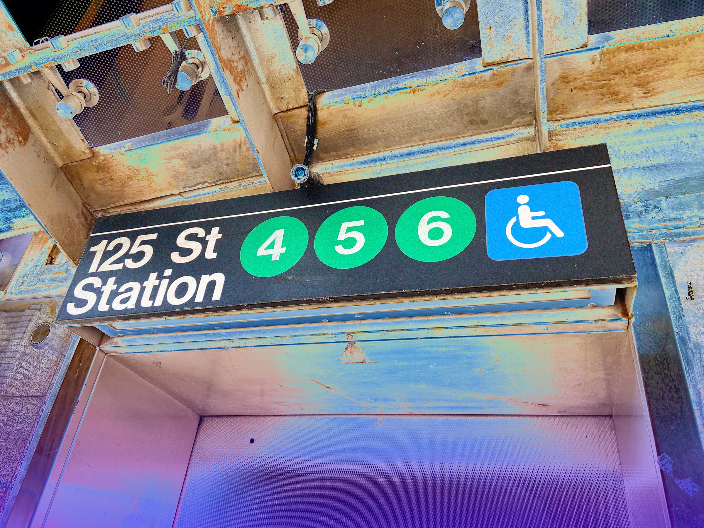 A sign for the 456 subway at 125th St in NYC with a wheelchair symbol