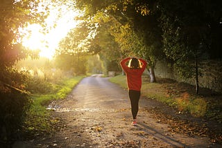 Woman walking down a trail in nature.