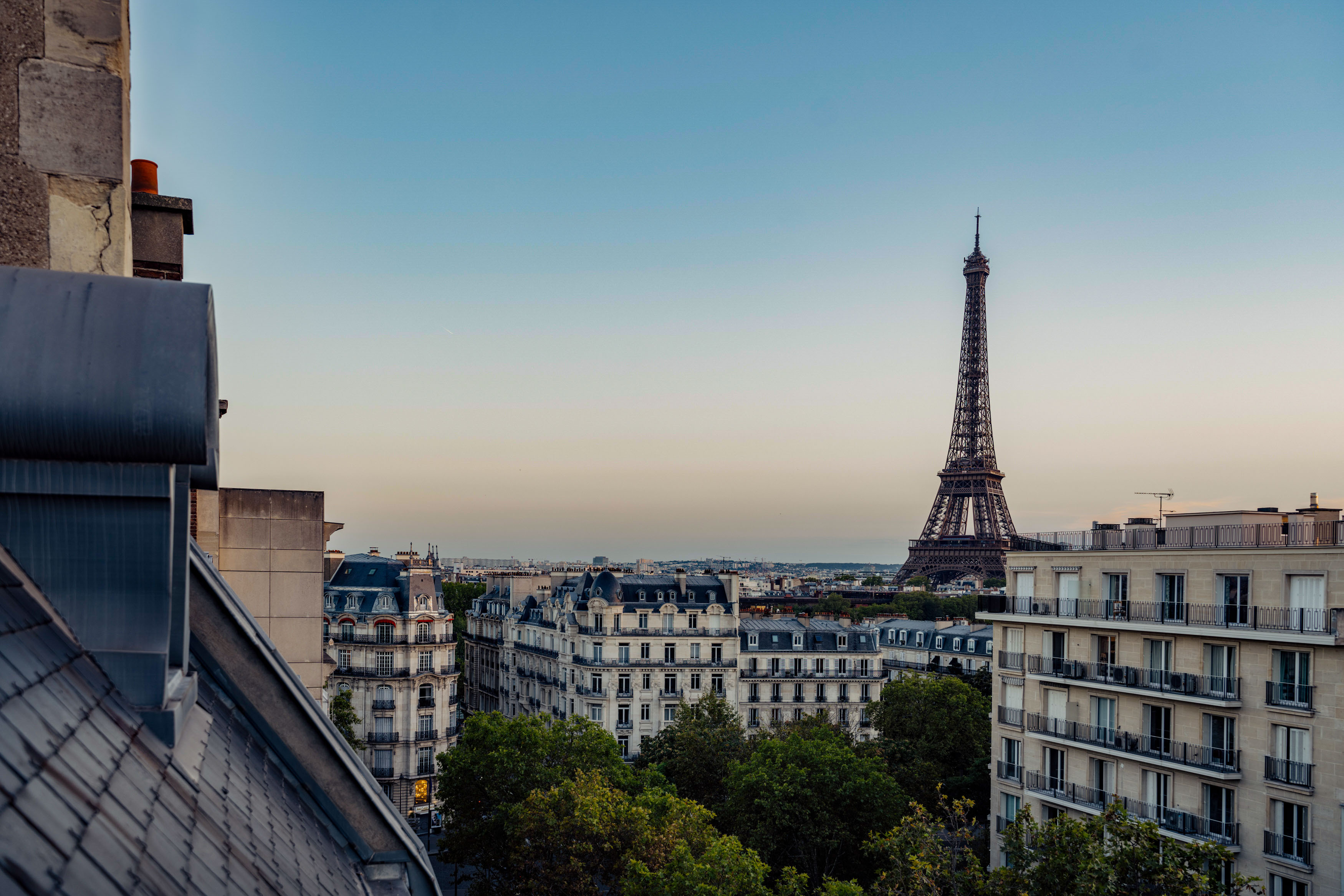 View of the Eiffel tower from an Airbnb in central Paris. Traditional rooftops in the foreground.