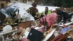 Rescuers work to free a man from a pile of rubble after a round of severe weather hit a mobile home park 