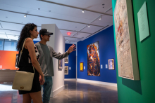 Guest visiting "A Banquet for Seaweed: Snapshots from the Arab 1980s" exhibition in the CVAD Gallery.