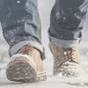 Person's boots walking in the ice and snow