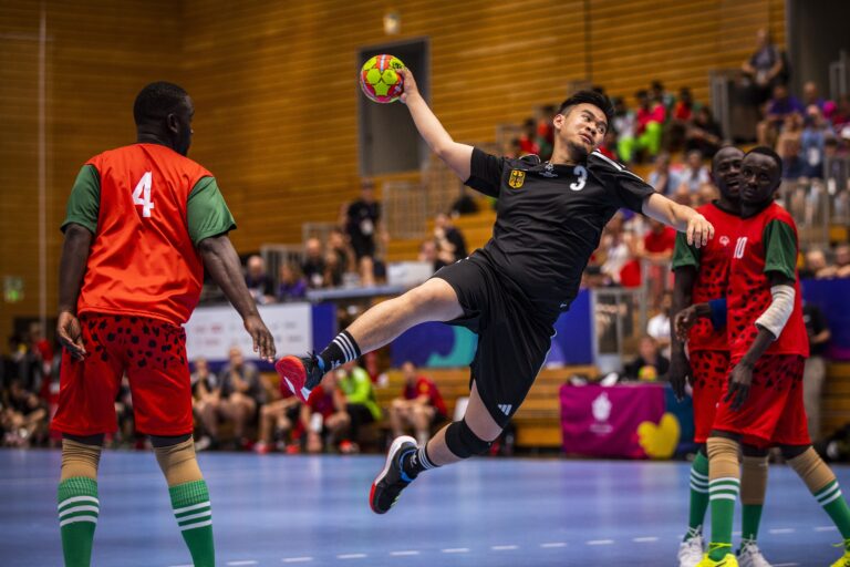 A participant in the Special Olympics catches a handball on court.