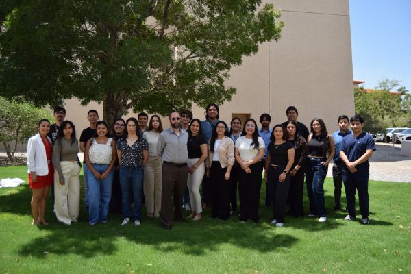 A diverse group of researchers, many of them students, gather for a group photo.