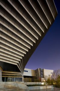 Concrete and metal panels create a uniform facade, concealing the complexity within.