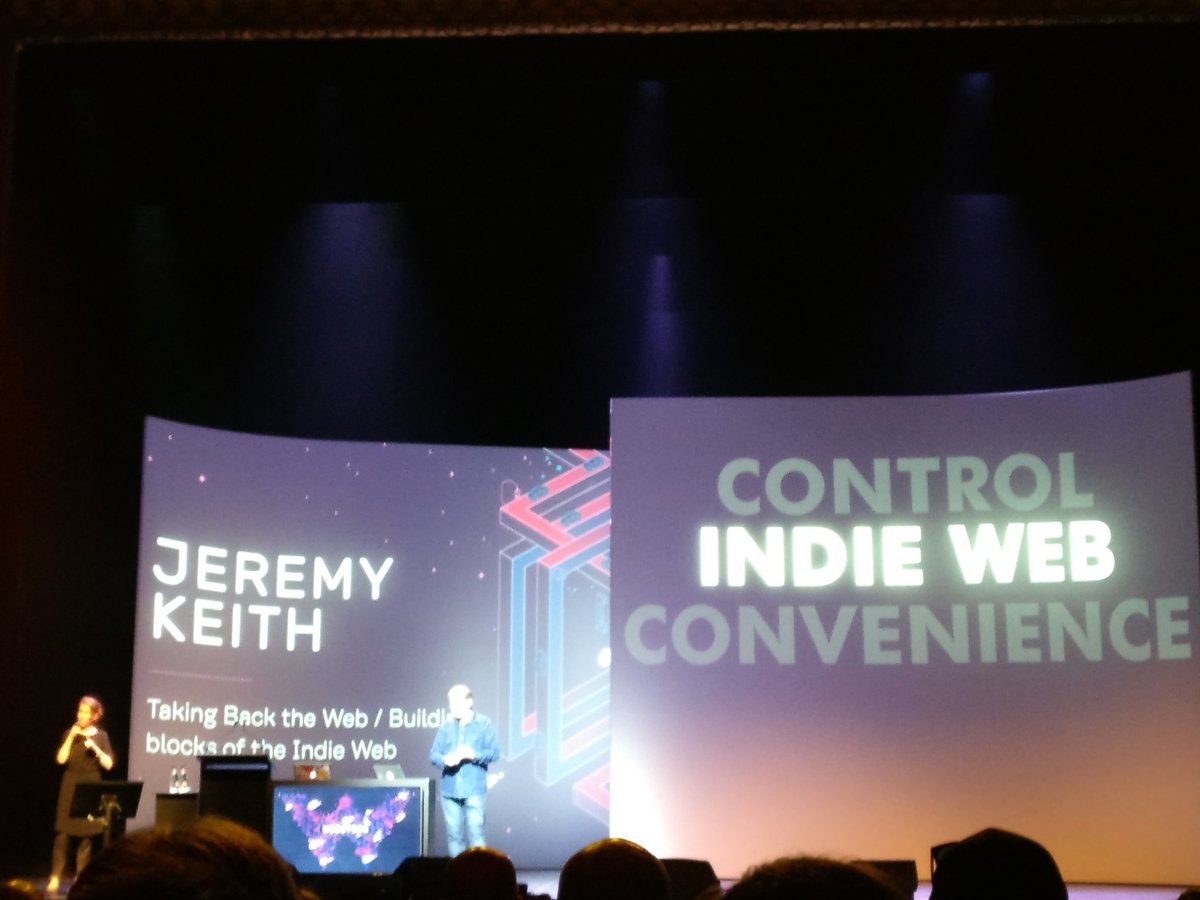 Jeremy Keith speaking on a stage with two large screens behind him about his talk “Taking Back the Web / Building blocks of the Indie Web”