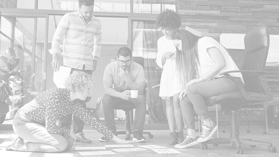 Photo of a group of students gathered around project materials spread on the floor