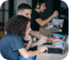 Three members of the team working on their devices.